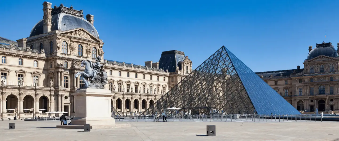The glass pyramid in the Cour Napoléon at the Louvre, with the museum’s palace wings behind it